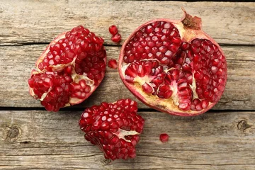 Fotobehang Cut fresh pomegranate on wooden table, top view © New Africa