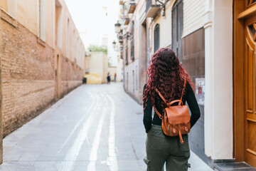 Girl walks through the streets of the old town of Zaragoza, Spain. His back is turned and he is...