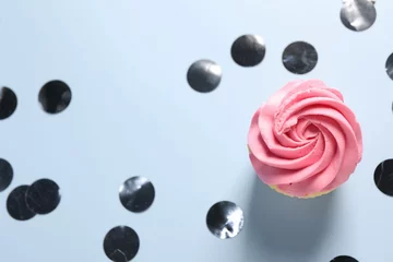 Gordijnen Delicious cupcake with bright cream and confetti on light background, flat lay © New Africa