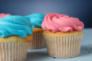 Gordijnen Delicious cupcakes with bright cream on blue background, closeup © New Africa