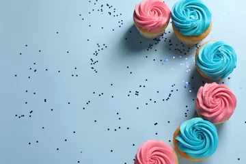 Wandcirkels plexiglas Delicious cupcakes with bright cream and confetti on light blue background, flat lay. Space for text © New Africa