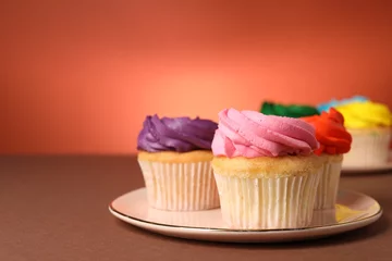 Schilderijen op glas Delicious cupcakes with bright cream on color background, space for text © New Africa