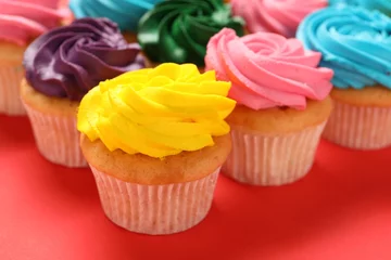 Gordijnen Delicious cupcakes with bright cream on red background, closeup © New Africa