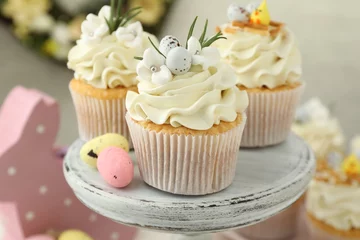 Schilderijen op glas Tasty Easter cupcakes with vanilla cream and candies on cake stand, closeup © New Africa