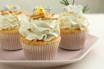 Rolgordijnen Tasty Easter cupcakes with vanilla cream on light table, closeup © New Africa