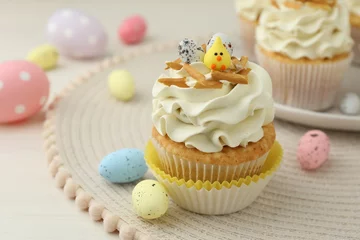 Gordijnen Tasty Easter cupcakes with vanilla cream and candies on table, closeup © New Africa