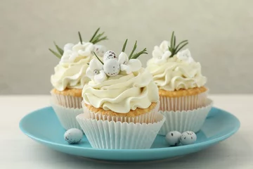 Outdoor kussens Tasty Easter cupcakes with vanilla cream on light wooden table, closeup © New Africa
