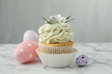 Plexiglas foto achterwand Tasty Easter cupcake with vanilla cream and eggs on white marble table © New Africa