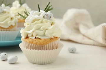 Foto op Canvas Tasty Easter cupcakes with vanilla cream on light wooden table © New Africa