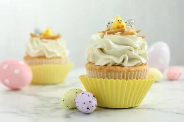Plexiglas foto achterwand Tasty Easter cupcakes with vanilla cream and candies on white marble table © New Africa