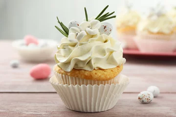 Gordijnen Tasty Easter cupcake with vanilla cream on wooden table © New Africa