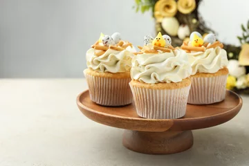 Foto op Canvas Tasty Easter cupcakes with vanilla cream on gray table, space for text © New Africa