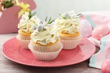 Gordijnen Tasty Easter cupcakes with vanilla cream on wooden table © New Africa