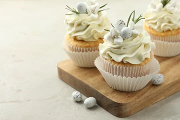 Foto op Aluminium Tasty Easter cupcakes with vanilla cream and candies on gray table, closeup. Space for text © New Africa