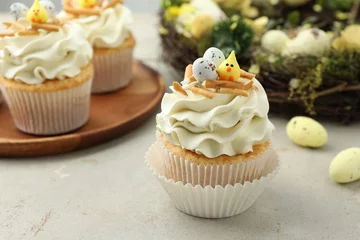 Outdoor kussens Tasty Easter cupcakes with vanilla cream and festive decor on gray table © New Africa