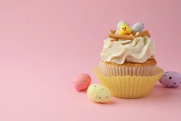 Gordijnen Tasty Easter cupcake with vanilla cream and candies on pink background, space for text © New Africa