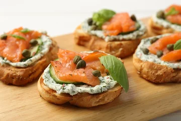 Fotobehang Tasty canapes with salmon, capers, cucumber and sauce on table, closeup © New Africa