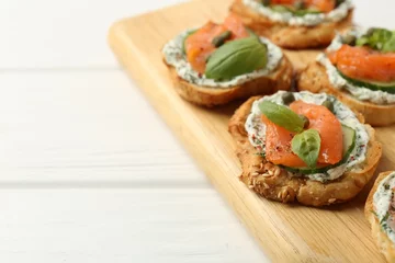 Zelfklevend Fotobehang Tasty canapes with salmon, capers, cucumber and sauce on white wooden table, closeup. Space for text © New Africa