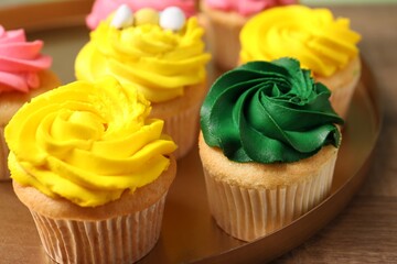 Delicious cupcakes with bright cream on table, closeup