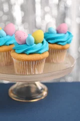 Zelfklevend Fotobehang Tasty decorated Easter cupcakes on blue table, closeup © New Africa