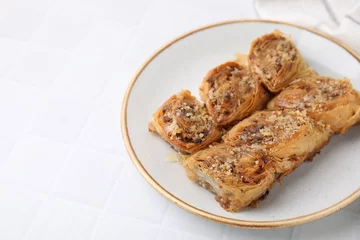 Deurstickers Eastern sweets. Pieces of tasty baklava on white tiled table. Space for text © New Africa