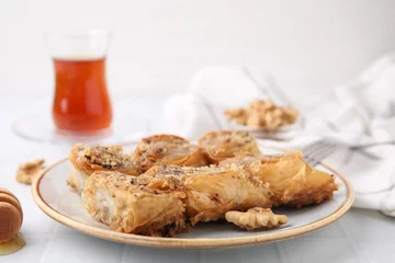  Eastern sweets. Pieces of tasty baklava on white tiled table, closeup © New Africa
