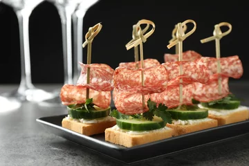 Foto op Canvas Tasty canapes with salami, cucumber and cream cheese on grey table, closeup © New Africa