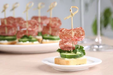 Foto op Canvas Tasty canapes with salami, cucumber and cream cheese on light table, closeup. Space for text © New Africa