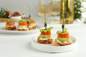 Rolgordijnen Tasty canapes with salmon, cucumber, bread and cream cheese on white wooden table © New Africa