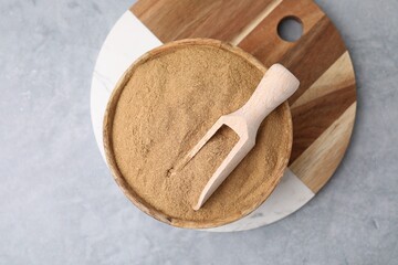Dietary fiber. Psyllium husk powder in bowl and scoop on grey table, top view