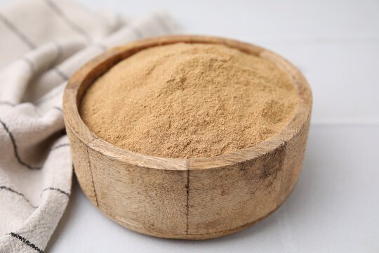 Dietary fiber. Psyllium husk powder in bowl on white table, closeup