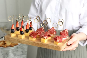 Fotobehang Woman holding tray of different tasty canapes indoors, closeup © New Africa