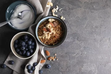 Plexiglas foto achterwand Tasty granola in bowl, blueberries, yogurt and spoon on gray textured table, flat lay. Space for text © New Africa