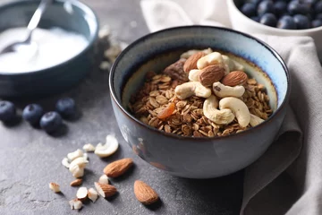Plexiglas foto achterwand Tasty granola with nuts in bowl on gray table, closeup © New Africa