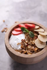 Foto op Plexiglas Tasty granola with yogurt, banana and strawberry in bowl on gray textured table, closeup © New Africa