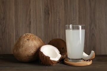 Glass of coconut water and nuts on wooden table - obrazy, fototapety, plakaty