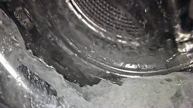 super slow-motion of water splashing in a washing machine, heavy interpolation artifacts in video made with a cellphone