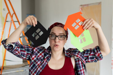 Woman in glasses holds colorful houses in her hands, color selection concept. High quality photo