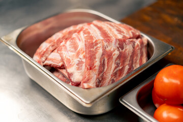 close-up in professional kitchen in a rib cage there are ribs for cooking on an iron table