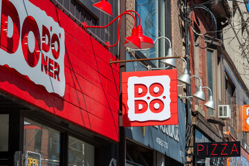 Fototapeta premium exterior buildings and sign of DoDoner, a doner kebah restaurant located at 1132 Queen Street West in Toronto, Canada