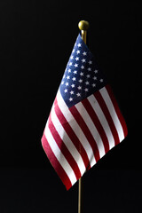 Small USA flag on black isolated background