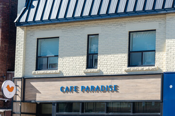Fototapeta premium exterior facade and sign of Cafe Paradise, a cafe, located at 1014 Bloor Street West in Toronto, Canada
