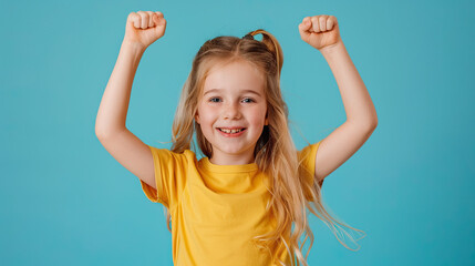 Fototapeta premium Portrait of a happy young blonde girl celebrating success on pastel blue background