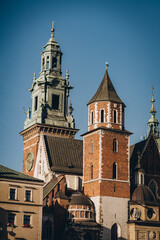 Fototapeta premium Clock and statues on stone medieval tower of Wawel Royal Castle, Krakow, Poland