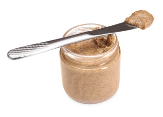 Tasty nut paste in jar and knife isolated on white