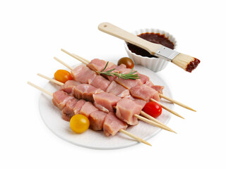 Skewers with pieces of raw meat, rosemary, tomatoes and marinade isolated on white