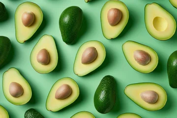 Foto op Canvas Fresh ripe avocados on a vibrant green background, arranged in a top view flat lay composition © SHOTPRIME STUDIO