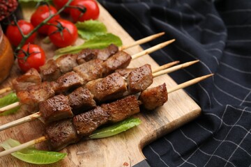 Tasty cooked marinated meat served with sauce and tomatoes on table, closeup
