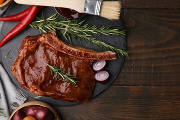 Tasty meat, rosemary, marinade and vegetables on wooden table, flat lay. Space for text