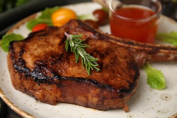 Tasty grilled meat, rosemary and marinade on plate, closeup